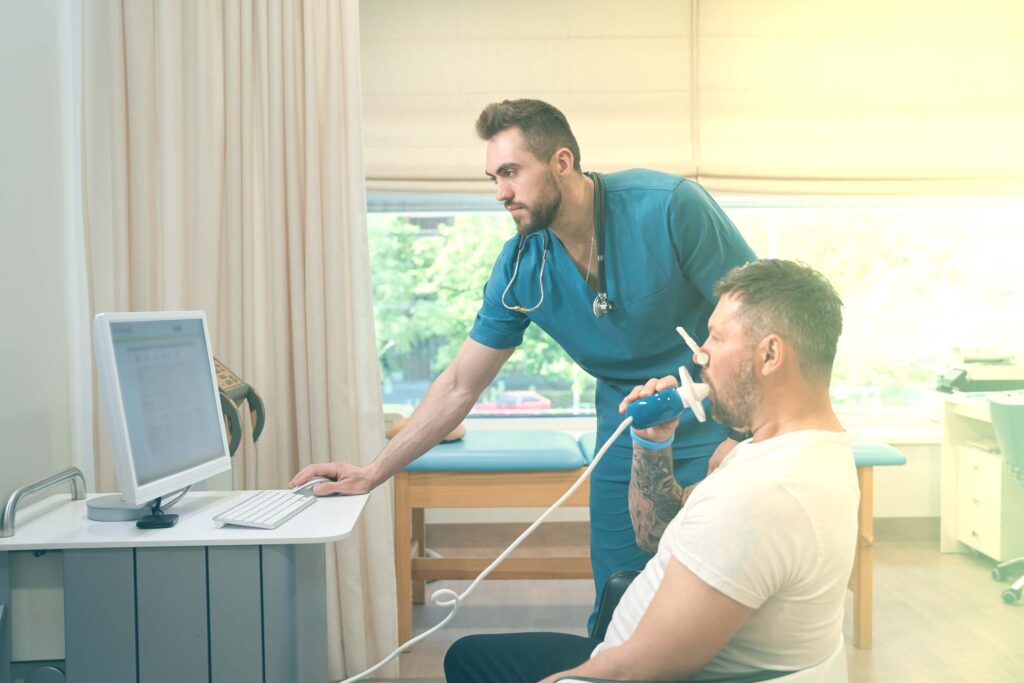 Homme subissant une évaluation en pulmonologie avec un inhalothérapeute.